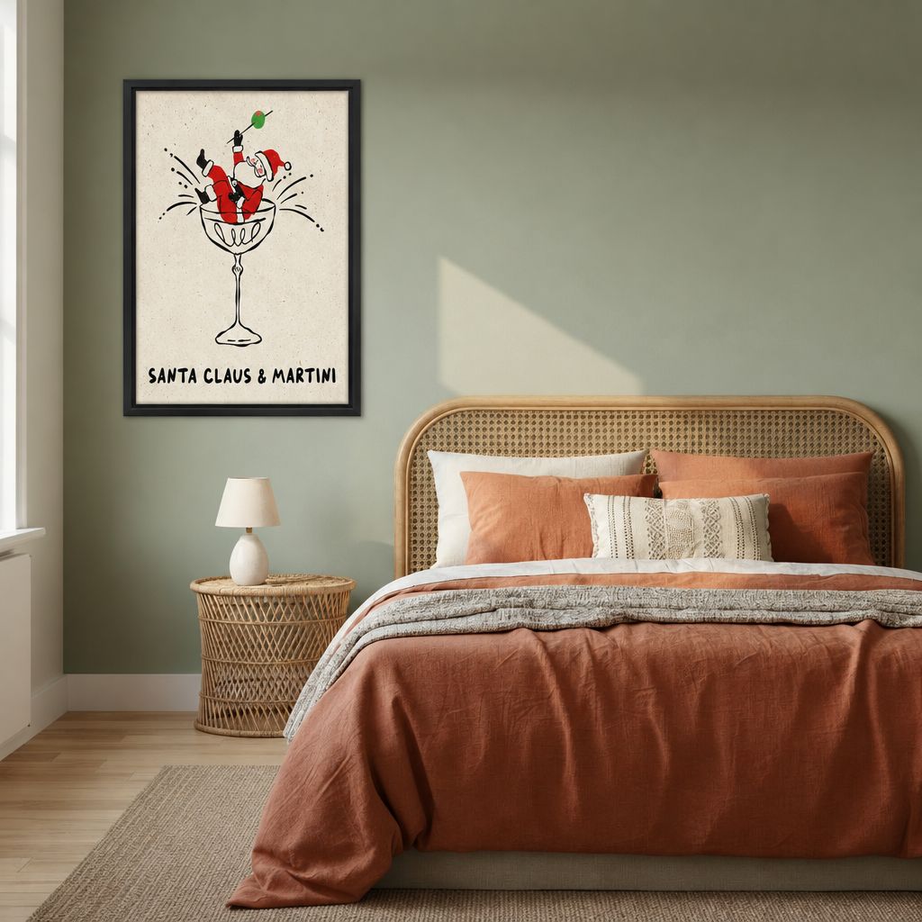 Black-framed whimsical Santa martini canvas wall art beside a bed with rust-colored bedding and a woven headboard.