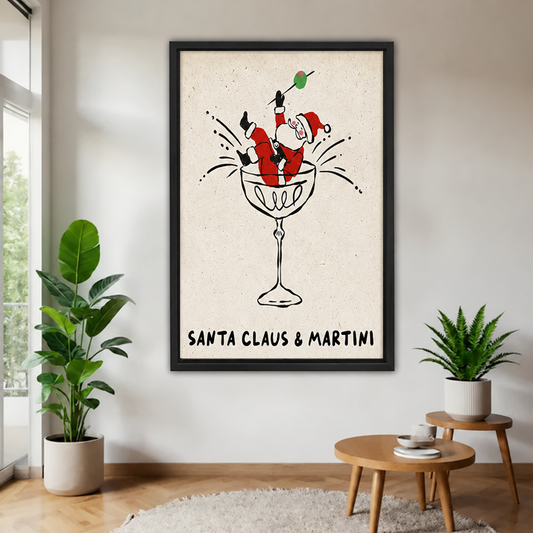 Black-framed whimsical Santa martini canvas wall art with “Santa Claus & Martini” lettering, displayed between plants near a window.