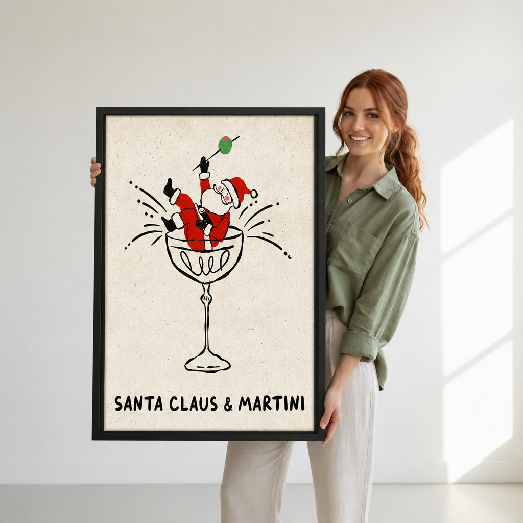 Woman holding black-framed whimsical Santa martini canvas wall art featuring Santa in a cocktail glass raising an olive.