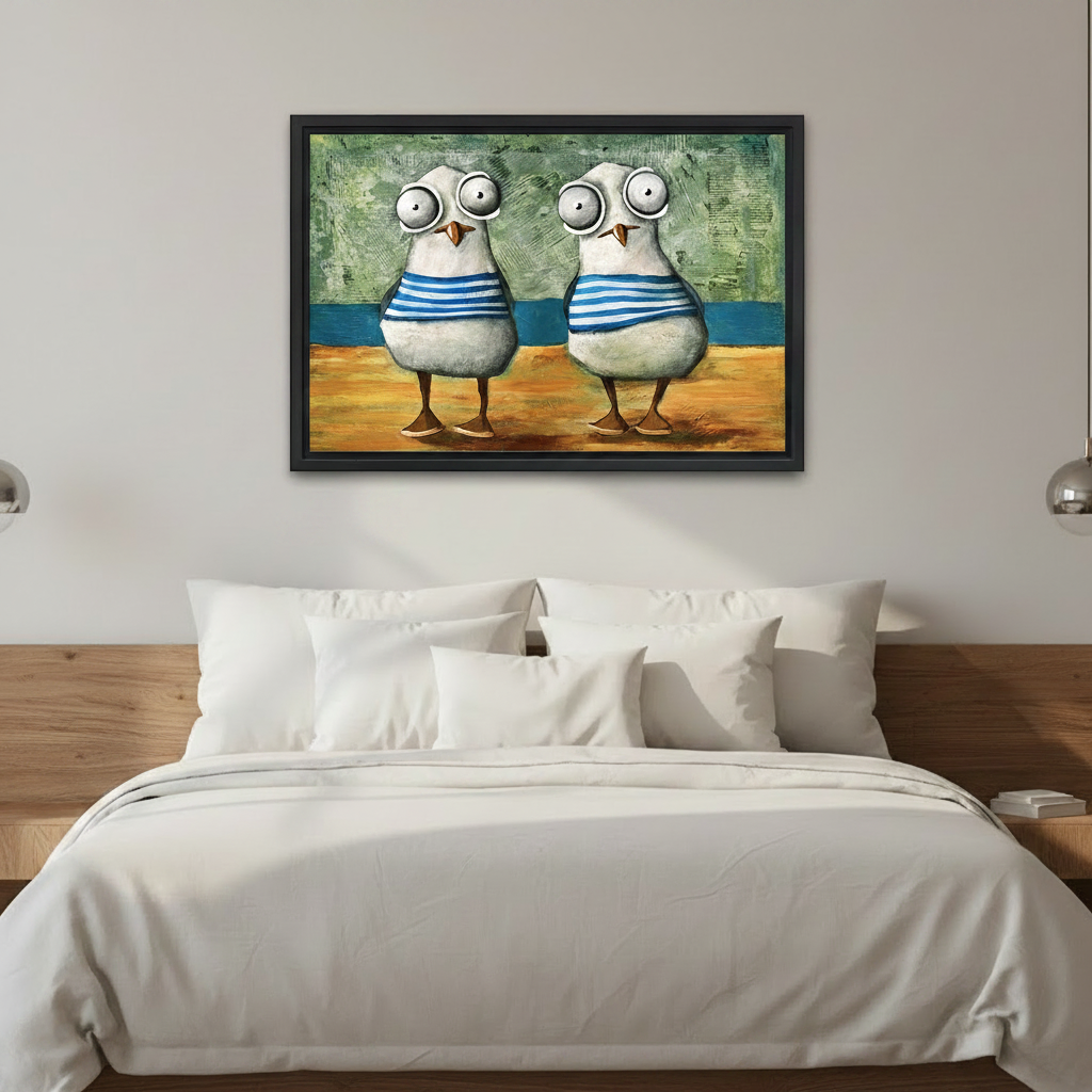 Framed coastal wall art featuring two cartoon-style seagulls in blue sailor stripes, mounted above a white bedding bed as bedroom decor
