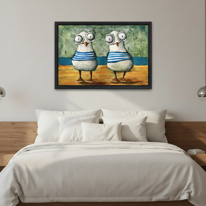 Framed coastal wall art featuring two cartoon-style seagulls in blue sailor stripes, mounted above a white bedding bed as bedroom decor