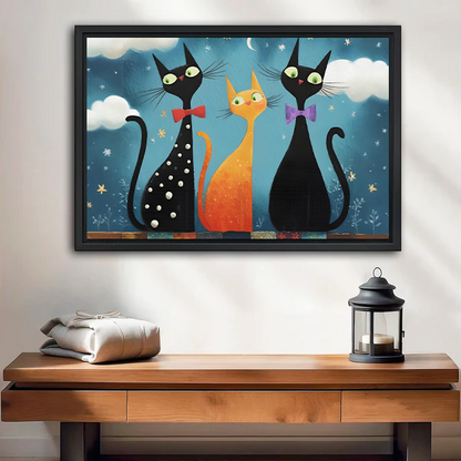 Whimsical three cat night canvas wall art in a black frame above a living room sofa