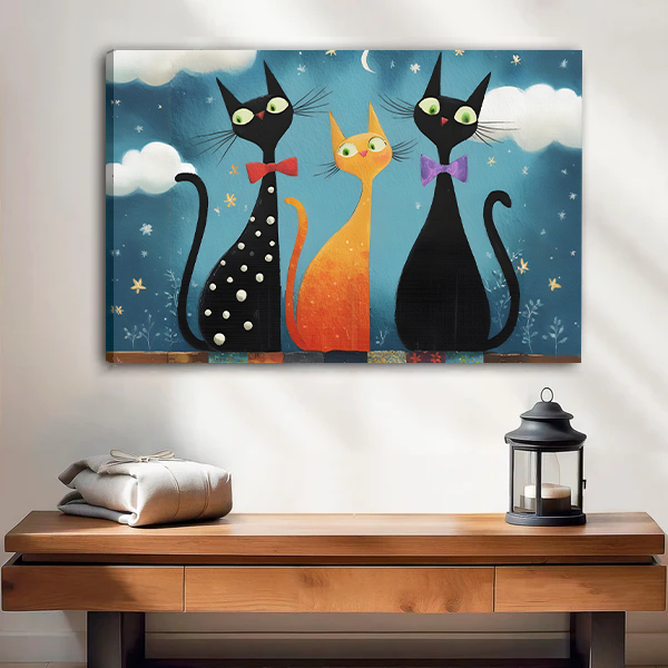 Framed whimsical three cat night canvas wall art displayed above a wooden console with a lantern