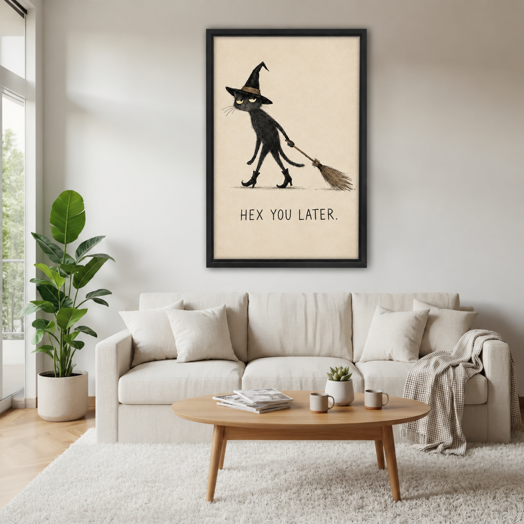Black-framed whimsical witch cat canvas wall art above a cream sofa, with a wooden coffee table and potted plant.