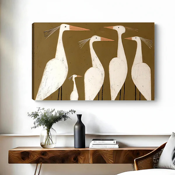 Woman holding black-framed white egrets canvas wall art featuring five cream-colored birds with peach beaks and slender legs.