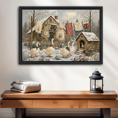 Woman holding framed winter geese canvas wall art featuring a snowy cottage yard and patterned linens on a clothesline.
