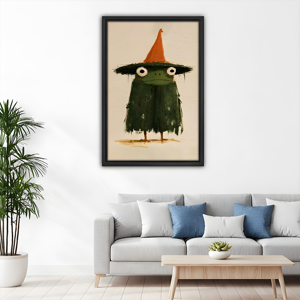 Black-framed witch frog canvas wall art with a cream background displayed above a wooden dining table.