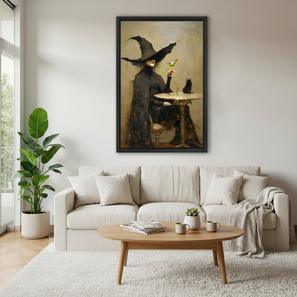Framed vintage witch martini and black cat canvas wall art beside two plants and a round wood table