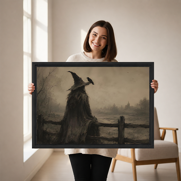 Framed witch and raven canvas wall art with muted sepia tones hanging above a bed with white bedding.