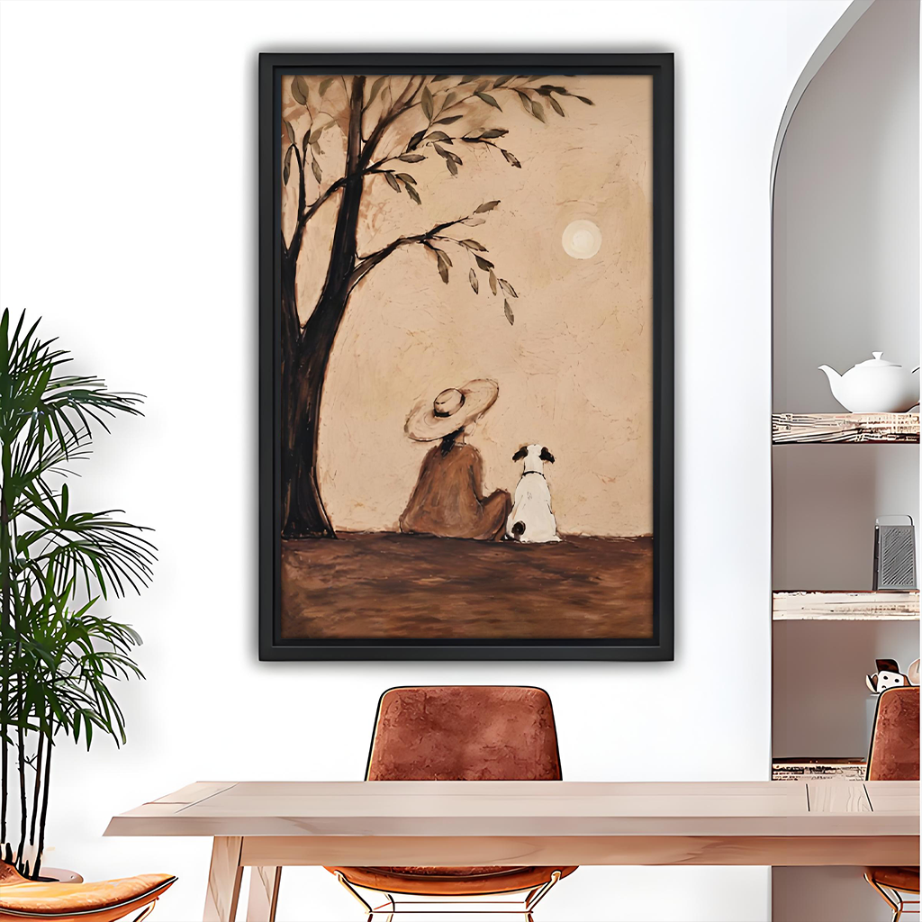 Framed rustic woman and dog under tree canvas wall art hanging above a grey sofa with blue cushions