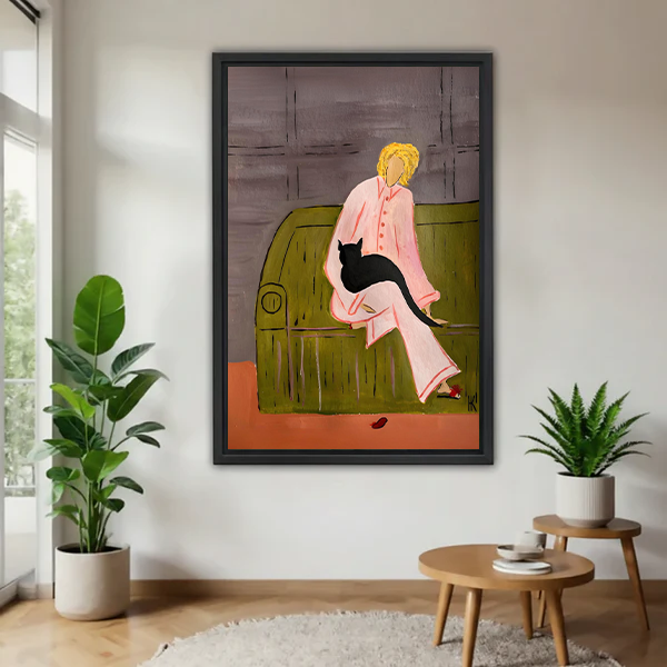 Modern woman with black cat canvas wall art in a black frame above a cream living room sofa.