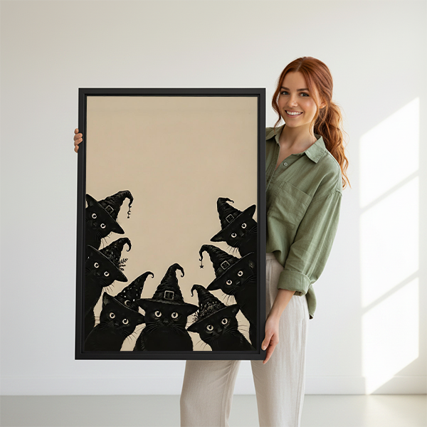 Framed black cat Halloween canvas wall art with playful witches displayed between plants in a bright room