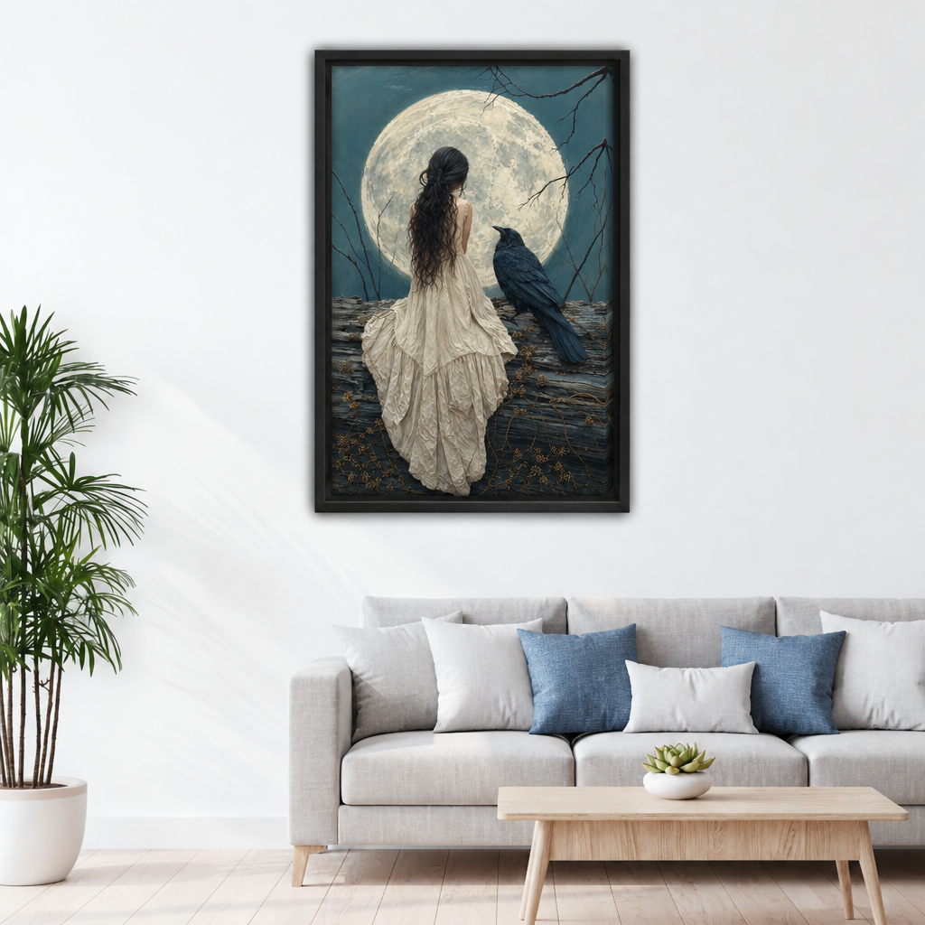 Woman and raven moon canvas wall art in a black frame displayed above a living room sofa.