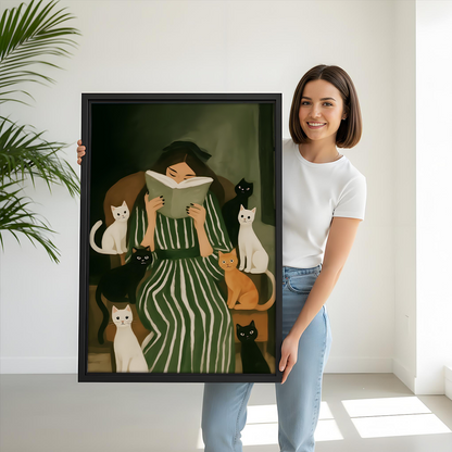 Woman reading with cats canvas wall art held by a smiling woman, showing the framed artwork's scale